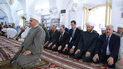 President Bashar Assad, third from right, prays on the first day of Eid Al Fitr at the Nouri Mosque in Hama. Sana via AP Photo