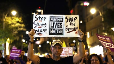 A protester holds an anti-war placard during a demonstration in Jerusalem on Saturday. AFP