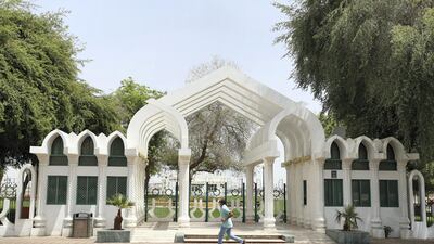 A man wearing a facemask runs past a closed park in Al Ain. Chris Whiteoak / The National