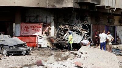 People inspect the scene of a car bomb attack in the Karrada neighborhood of Baghdad. A spate of bombings and shootings rocked the country today.