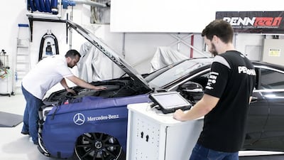 Mechanics work on a vehicle in Silber Arrows Garage. Mechanics said fake car parts are becoming harder to spot. Reem Mohammed / The National