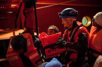Rescue staff members evacuate a child, as a group of migrants are transferred on December 26 2017, from the Spanish war ship Santa Maria to the non-governmental organization (NGO) Aquarius ship by SOS Mediterranee and Medecins sans Frontieres (MSF - Doctors Without Borders) NGOs. Federico Scoppa / AFP