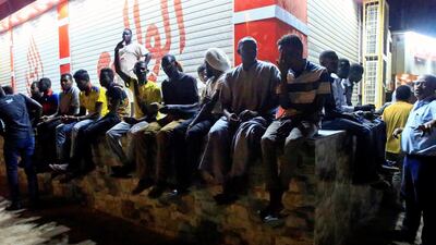 Civilians sit on a wall near the area where gunmen opened fire outside buildings used by Sudan's National Intelligence and Security Service (NISS) in Khartoum, Sudan January 14, 2020. Reuters