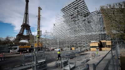 Workers build stands for this summer's Olympic Games on the Champ-de-Mars, beside the Eiffel Tower in Paris. AP