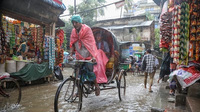 A rickshaw driver ploughs through a flooded street during heavy rain in Dhaka, Bangladesh. EPA