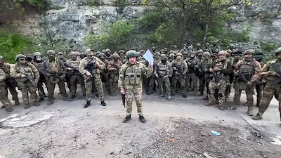 A video posted to Telegram appears to show Yevgeny Prigozhin, centre, surveying the body of an American whom the Wagner chief says was killed near Bakhmut, Ukraine. AFP