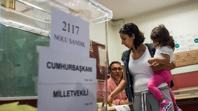 A woman picks up a ballot at a polling station in Istanbul, Turkey, on June 24, 2018. Yasin Akgul / AFP