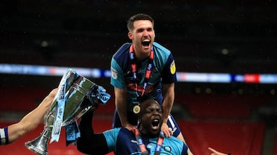 Wycombe Wanderers' Adebayo Akinfenwa (bottom) celebrates with the trophy after winning the League One play-off final at Wembley Stadium. PA