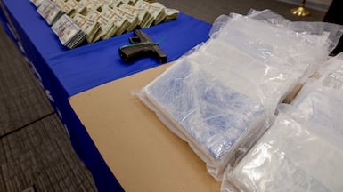 Cash, fentanyl and a pistol on display at FBI headquarters in Atlanta, Georgia. Two men were facing federal charges last month after 21kg of the drug were confiscated in a raid in Forest Park. EPA