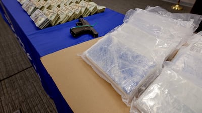 Cash, fentanyl and a pistol on display at FBI headquarters in Atlanta, Georgia. Two men were facing federal charges last month after 21kg of the drug were confiscated in a raid in Forest Park. EPA