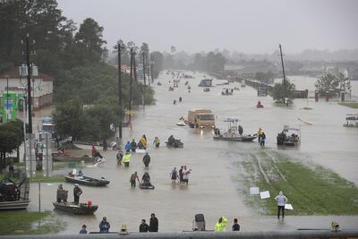 People walk down a flooded street after flooding from Hurricane Harvey. Raedle / Getty Images