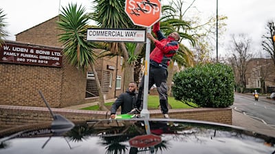 A person removes an artwork by Banksy in Peckham, south-east London, on December 22. All photos: PA