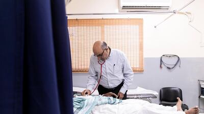 Dr Sanjay Paithankar treats low-income workers at Right Health New Sanaiya Clinic. Reem Mohammed / The National