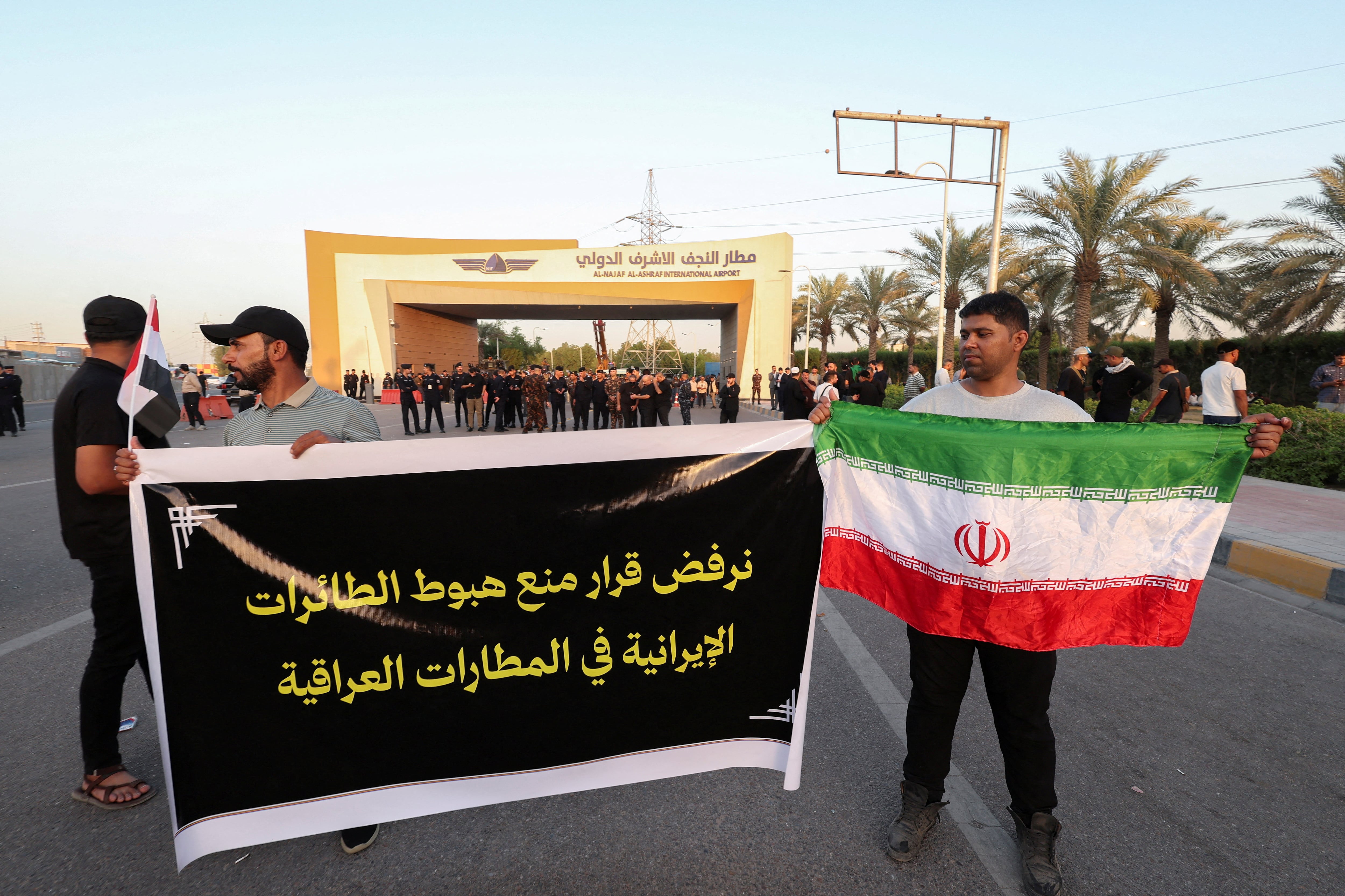 A demonstrator holds an Iranian flag during a protest against US restrictions on Iran's civil aviation, outside Najaf Airport, Iraq, last month. Reuters