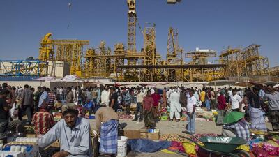 At the Mussaffah Friday bazaar, workers from the labour camps cook, sew cloths, slaughter goats, give hair cuts, and gamble. Mona Al-Marzooqi / The National
