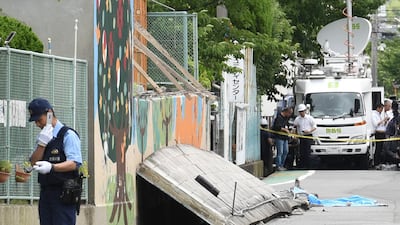 A policeman stands guard near a collapsed wall where a girl died following an earthquake in Takatsuki City, north of Osaka. AFP