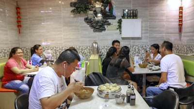 A customer enjoys his Lanzhou hand pulled noodles at the Dragon Bao Bao in Abu Dhabi. Victor Besa / The National