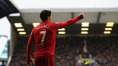 Luis Suarez of Liverpool holds up a coin thrown from the crowd during the Merseyside derby at Goodison Park. Clive Brunskill/Getty Images