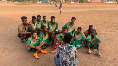 Sudanese football coach Monzer Hassan speaks with his players.