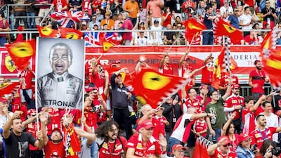 Ferrari fans hold up a banner featuring Lewis Hamilton of Mercedes. Getty
