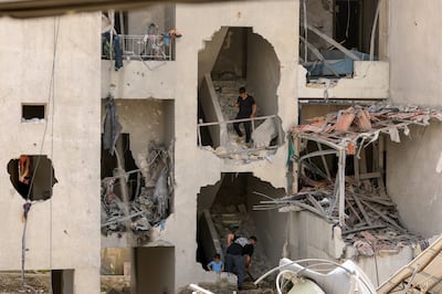 Residents clear debris from their homes after returning to Nabatieh in southern Lebanon. EPA