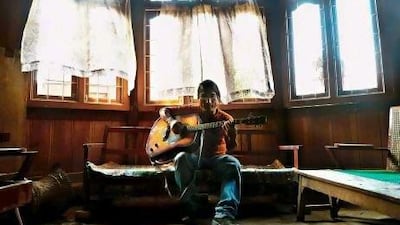 Jianngam Kamei, a popular local music director, plays his guitar in a room in Imphal, the capital of the north eastern Indian state of Manipur.