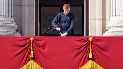 A Buckingham Palace staff member cleans the balcony where the queen is expected to wave to well-wishers. AFP