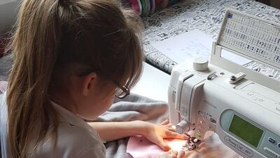 Amira and Thomas Lillywhite stitch together a blanket to send to their ailing family pet in the UK. Courtesy - Hannah Lillywhite