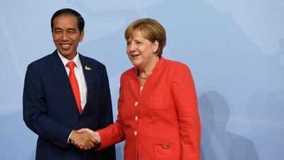 German Chancellor Angela Merkel welcomes Indonesia's President Joko Widodo as he arrives to attend the G20 summit in Hamburg, northern Germany, on July 7, 2017. Leaders of the world's top economies gather from July 7 to 8, 2017 in Germany for likely the stormiest G20 summit in years, with disagreements ranging from wars to climate change and global trade. / AFP PHOTO / SAUL LOEB