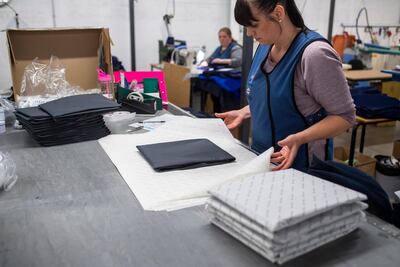 A woman packs NHS uniforms at a factory in Dukinfieldin, England. Getty