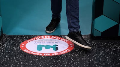 Social distance markers are placed on the floor of the Museum of Illusion in Paris, advising visitors to keep a safe six-foot distance from each other. AFP