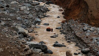 Rescuers try to make their way upstream as they search through mud and debris for a third day after landslides set off by torrential rains in Wayanad district, Kerala state, India. AP