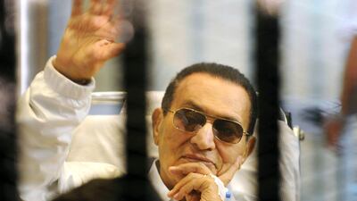 FILE - In this April 13, 2013 file photo, former Egyptian President Hosni Mubarak waves to his supporters from behind bars as he attends a hearing in his retrial on appeal in Cairo, Egypt. Egypt's state TV said Tuesday, Feb. 25, 2020, that the country's former President Hosni Mubarak, ousted in the 2011 Arab Spring uprising, has died at 91. Mubarak, who was in power for almost three decades, was forced to resign on Feb. 11, 2011, after following 18 days of protests around the country. The Arab Spring uprisings had convulsed autocratic regimes across the Middle East. (AP Photo, File)