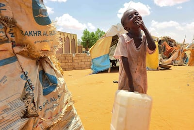 A Sudanese girl carries a water canister in Al Rahmaniyah camp near the city of Al Obeid in Kordofan. AFP
