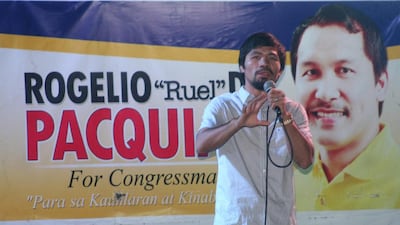 Boxing champion turned politician Manny Pacquiao with a poster of his brother Rogelio Pacquiao, who ran for congress, during a political campaign in General Santos City in southern island of Mindanao. Paul Bernaldez / AFP