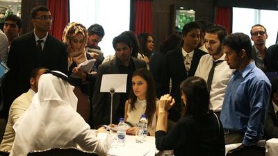 Yousef Ahmed Hamza, partner at Envestors, with his back to the camera, interviews young job seekers at The Talent Hunt organised by InternsME in Dubai. Pawan Singh / The National