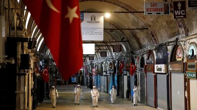 Workers in protective suits spray disinfectant at the Grand Bazaar, known as the Covered Bazaar, to prevent the spread of coronavirus in Istanbul, Turkey. REUTERS