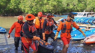 Rescuers carry the body of a victim. AP