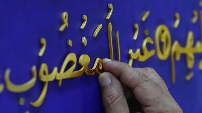 Shahid Rassam puts the final touches to a verse in Surah Al Fatiha, the first chapter of the Quran. EPA
