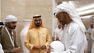Sheikh Mohamed bin Zayed signs a ball.