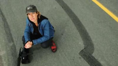 The Canadian film-maker Ariella Pahlke next to a tire skid mark in Terrence Bay, Nova Scotia.