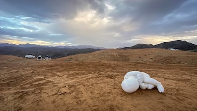A child sculpted in marble as he cradles with a chained wrist lies in the desert sand. Sculptor Jago took the statue and abandoned it in Fujairah. The statue, Look Down, was displayed for six months in Piazza del Plebiscito in Naples. Antonie Robertson / The National