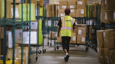 A worker walks past carts of packages ready for delivery drivers to pickup at a Veho Tech facility in Atlanta, Georgia. The impact of Covid-19 on the US economy has been severe, with unemployment rising to 14.7% in April 2020, the highest rate since the Great Depression. Bloomberg