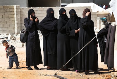 In this photo from another displacement camp, Syrian women wait for food collection outside a tent in al-Bab, northern Syria, Tuesday, May 29, 2018. Lefteris Pitarakis / AP