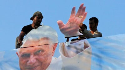 Workers hang a poster of Pope Benedict XVI, in Jounieh, north of Beirut, in preparation for his arrival for a three-day visit to Lebanon. Jamal Saidi / Reuters