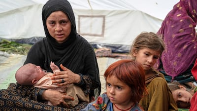 A woman and her children wait for assistance in the village of Wadir. AP