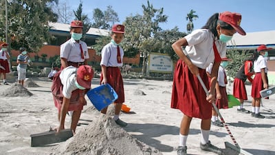 Students clean their school yard from ash after the Mount Sinabung volcano erupted on Monday at Payung village in Karo, North Sumatra. Antara Foto / Ahmad Putra / via Reuters