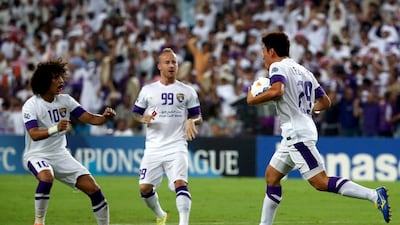 Al Ain midfielder Lee Myung-joo, right, celebrates his goal with teammates Omar Abdulrahman, left, and Miroslav Stoch during their Asian Champions League semi-final match against Saudi's Al Hilal on September 30, 2014 at Hazza Bin Zayed Stadium. AFP PHOTO/MARWAN NAAMANI