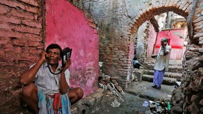 Labourer's speak on wireless phones in an alley outside a local telephone booth in Kolkata. Rupak De Chowdhuri / Reuters