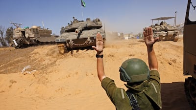 An Israeli soldier directs armoured vehicles near the Rafah border crossing in the southern Gaza Strip. Bloomberg
